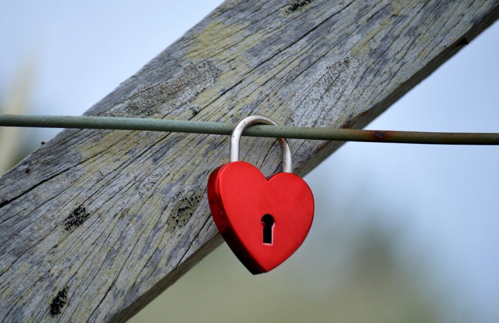 Candado en forma de corazón cerrado en una valla