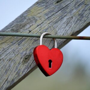 Candado en forma de corazón cerrado en una valla