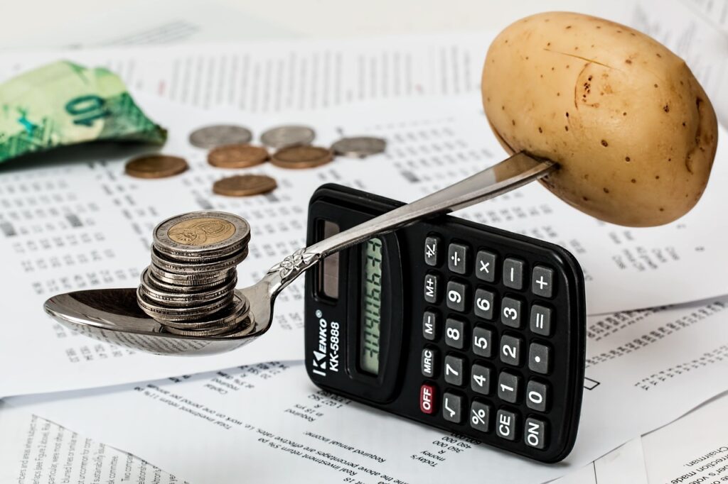 Monedas junto a una calculadora para organizar el presupuesto, horóscopo financiero de hoy