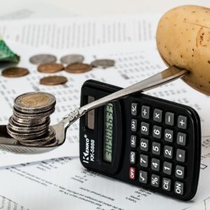 Monedas junto a una calculadora para organizar el presupuesto, horóscopo financiero de hoy