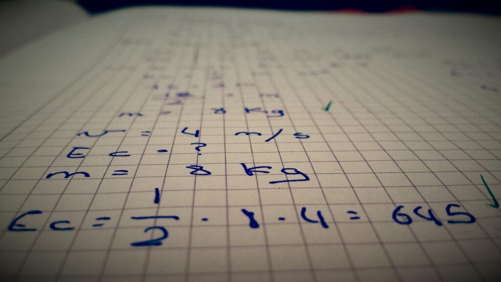 Cuaderno con operaciones y números escritos a mano junto a una calculadora