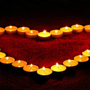 Velas encendidas formando un corazón, símbolo de un amarre de amor