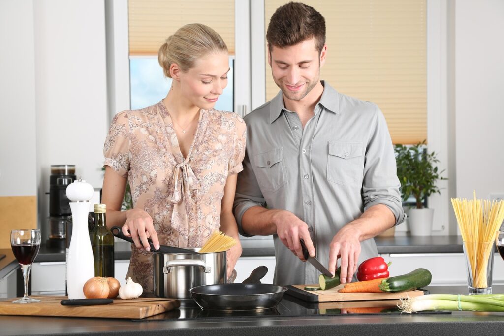 Pareja cocinando junta en casa, imagen de complicidad y cuidado cotidiano en la relación
