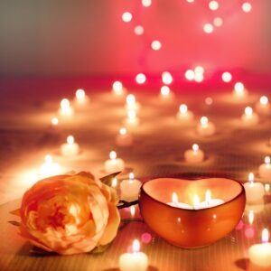 Velas encendidas junto a flores rosas