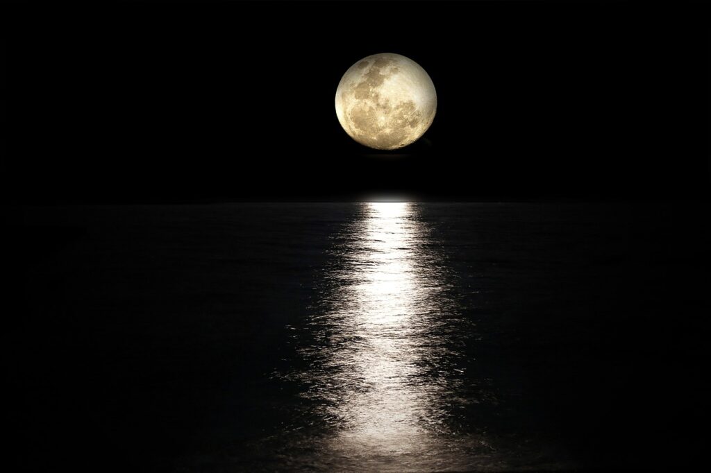Luna llena reflejada sobre el mar en un cielo nocturno