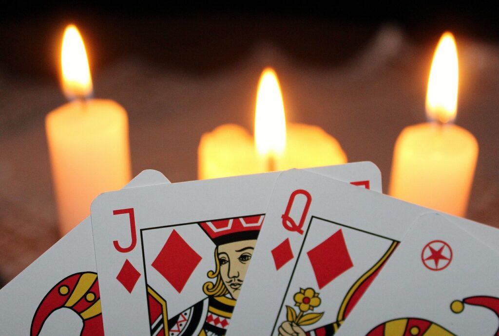 Vela encendida junto a cartas del tarot en la oscuridad
