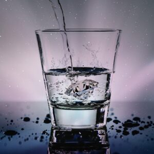Vaso de agua cristalina iluminado, usado para preparar agua de luna llena