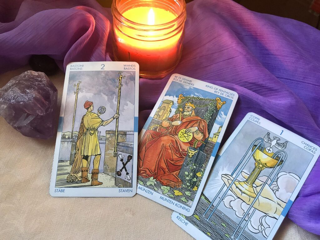 Cartas de tarot y vela encendida durante una lectura sobre el amor