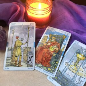 Cartas de tarot y vela encendida durante una lectura sobre el amor
