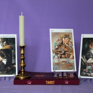 Cartas de tarot, un libro y una vela preparados para una consulta