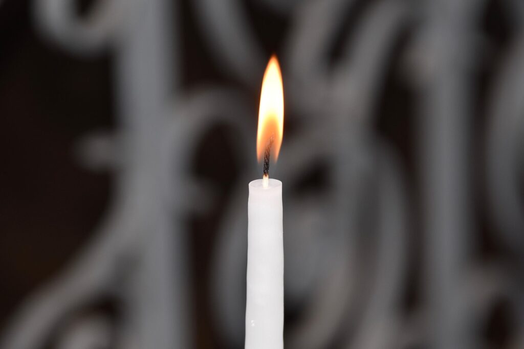 Vela blanca encendida para el ritual de abrir caminos