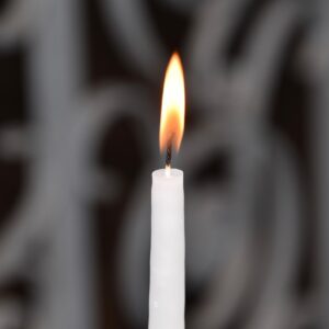 Vela blanca encendida para el ritual de abrir caminos