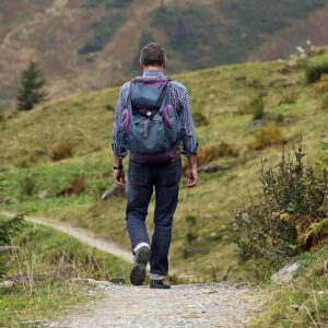 Excursionista con mochila caminando por un sendero de montaña