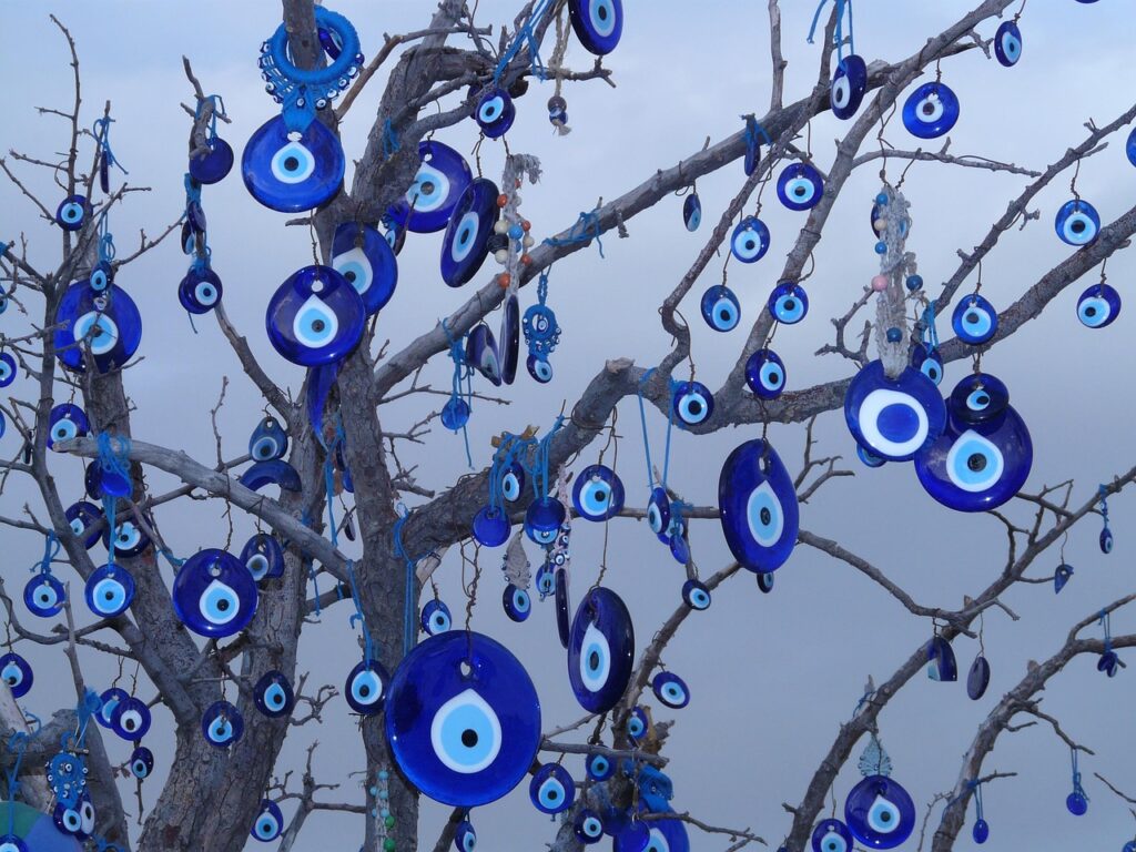 Amuleto de ojo turco colgado de una rama, protección tradicional contra el mal de ojo