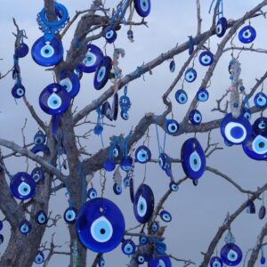 Amuleto de ojo turco colgado de una rama, protección tradicional contra el mal de ojo