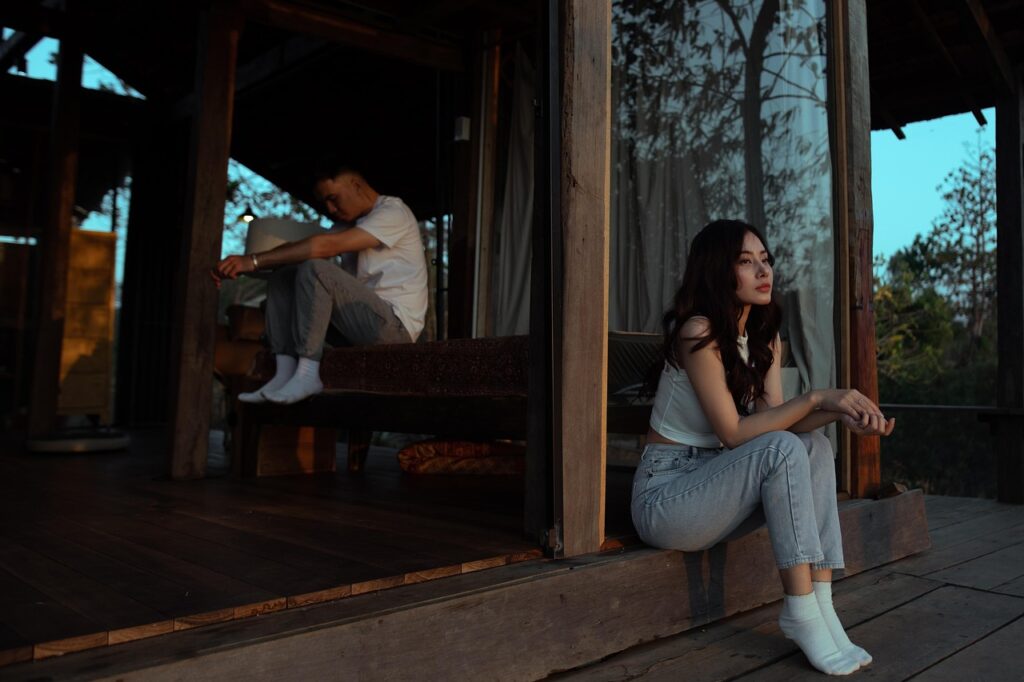 Pareja sentada en silencio en una habitación, reflejando distancia y problemas en la relación