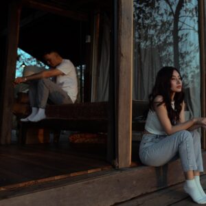 Pareja sentada en silencio en una habitación, reflejando distancia y problemas en la relación